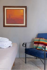 萨利纳斯Hostel Casa Betancourt的卧室配有蓝色椅子和壁画