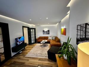 普里什蒂纳Stylish Downtown Apartment的带沙发和电视的客厅