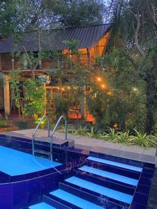 哈伯勒内Levona Garden Resort的一座晚上设有游泳池的房子