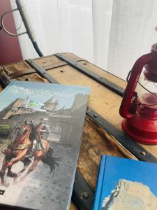 卡尔卡松La Belle Etape à Carcassonne的一张桌子,上面有两本书和红灯