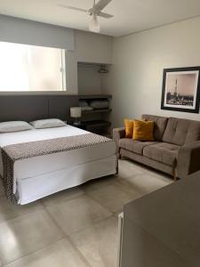 Três PontasHotel Ouro Verde的一间卧室配有一张床和一张沙发