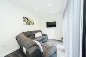曼彻斯特Modern 4-Bed Retreat with Garden的客厅配有棕色沙发和电视