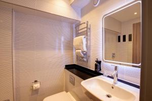 伦敦City Sleeper at Royal National Hotel的一间带水槽、卫生间和镜子的浴室