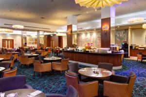 伦敦City Sleeper at Royal National Hotel的一间带桌椅的餐厅和一间酒吧