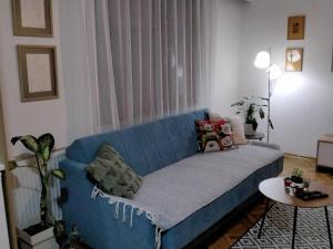 莱斯科瓦茨Fina Apartment的客厅配有一张蓝色的沙发,配有一张桌子