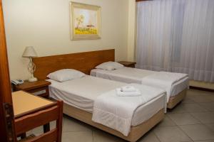格拉瓦塔伊Hotel Radar的酒店客房设有两张床和一张桌子。
