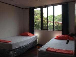 Santiago EsteEL-CACIQUE-guesthouse-since-2003的带窗户的客房内的两张床