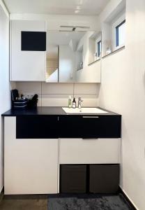 林茨Helle Wohnung in Top Lage!的厨房配有白色和黑色橱柜和水槽
