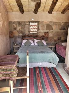 麦马拉El Cerrito的卧室配有一张石墙床