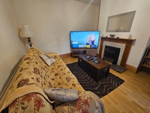 丁格尔Cois Chnoic的一间带床和电视的客厅