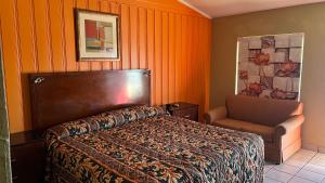 格林维尔格林维尔经济汽车旅馆的一间卧室配有一张床和一把椅子