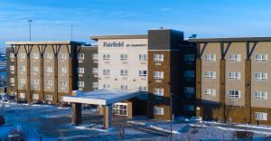 艾尔德里Fairfield Inn & Suites by Marriott Airdrie的前面有长凳的建筑