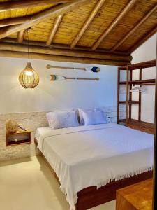 莫罗圣保罗Chalé Del Mar的卧室配有白色床和木制天花板