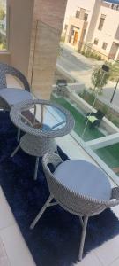马斯喀特Sifah Ocean Breeze Villa的庭院配有桌椅和窗户。