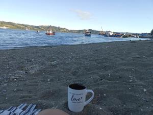 卡斯特鲁Hostal Sandrita的坐在海边的海滩上喝杯咖啡