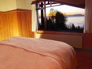 普孔普孔门户山林小屋的一间卧室设有一张床和一个美景窗户。