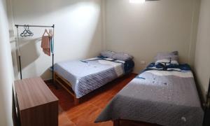 瓦努科DEPARTAMENTO AMOBLADO 4 Camas 3 habitaciones的客房设有两张床,铺有木地板。