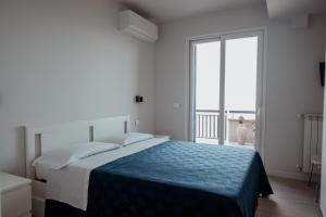陶尔米纳Blue Marine Taormina的一间卧室设有一张床和一个大窗户