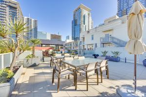 圣地亚哥High-End San Diego Condo with Pool and Rooftop Access的庭院配有桌椅和遮阳伞。