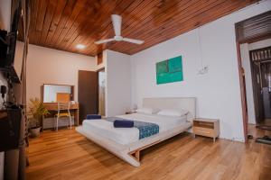科伦坡Drop Inn Hostels的一间卧室设有一张床和木制天花板