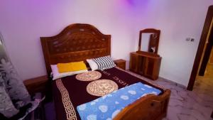 Sere KundaMarong Na kordaa的一间卧室配有一张带镜子的木床
