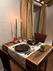 斯塔沃洛Gîte La Petite Francorchamps Ardennaise的一张木桌,上面放有盘子和酒杯