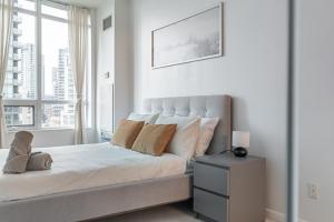 多伦多Fort York Apartments的白色卧室设有一张带窗户的床