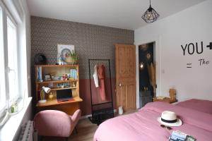 朗斯Maison cosy dans le centre ville de Lens的卧室配有粉红色的床和粉红色的椅子