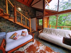 乌斯怀亚Patagonia Villa Lodge的带沙发和石墙的客厅