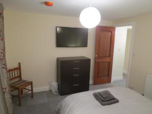 蒙特罗斯The Heritage Guest House的卧室配有一张床,墙上配有电视。