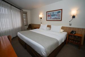 蒙特港多恩路易斯蒙特港酒店的配有一张大床和一部电话的酒店客房