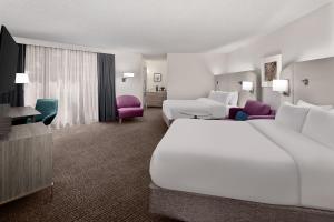 亚特兰大Crowne Plaza Atlanta Perimeter at Ravinia, an IHG Hotel的酒店客房带大型白色床和椅子