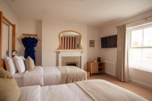布里斯托Lido Townhouse的一间卧室设有两张床、一个壁炉和一个镜子