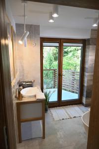 StryszawaChatka Beatki的一间带水槽和浴缸的浴室以及窗户。