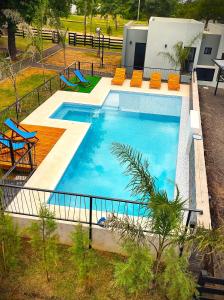 科隆Cabañas Posta Litoral的享有带橙色椅子的游泳池的顶部景致