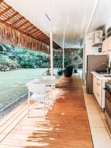 MahinaVaikea Fare的铺有木地板,设有带桌椅的厨房。