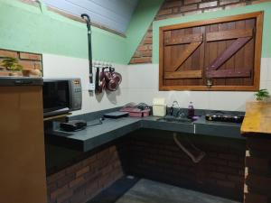 圣罗克迪米纳斯Pousada do Chicó的厨房配有带水槽和微波炉的台面