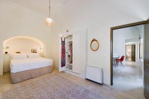 安坡里奥圣托里尼曼提利达别墅的一间卧室配有一张大床和镜子