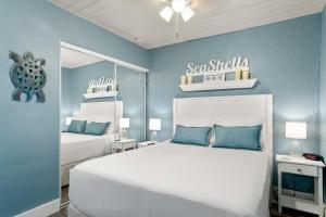 马拉松Seashells Getaway的一间卧室设有两张床和蓝色的墙壁