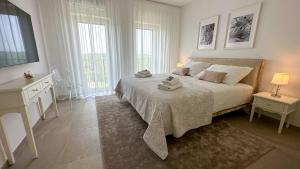 多博沃A Luxury 100m2 Apartment in a Chic Vineyard Villa - Ca' S. Lorenz的白色卧室设有一张大床和两个窗户