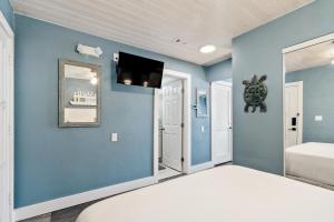 马拉松Seashells Getaway的蓝色卧室配有床和平面电视