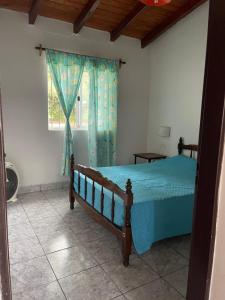AnimanáPULAKI Cabañas en Animana的一间卧室配有一张带蓝色棉被的床和窗户。