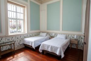 瓦尔帕莱索Casa Baron的带2扇窗户的客房内的2张床