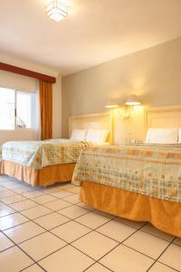 科利马玛丽亚伊莎贝尔酒店 的一间酒店客房,房间内设有两张床