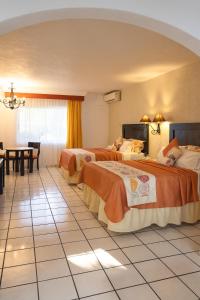 科利马玛丽亚伊莎贝尔酒店 的酒店客房设有两张床和一张桌子。