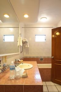 科利马玛丽亚伊莎贝尔酒店 的浴室配有盥洗盆、镜子和浴缸
