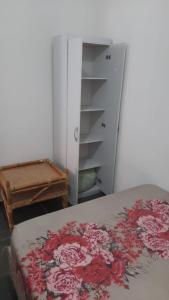 伊塔尼亚恩Apartamento em Itanhaém com 2 quartos, Piscina e Ampla Varanda Gourmet的一间卧室配有床和鲜花梳妆台。