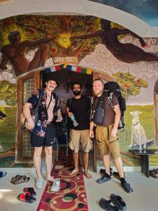 科钦Santa Maria Hostel, Fort Kochi的站在一幅画前面的三人小组