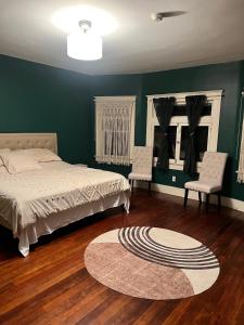洛杉矶Historical Retreat的一间卧室配有床、两把椅子和地毯