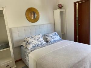 弗洛里亚诺波利斯Residencial Jurerê Belo的一间卧室配有一张带两个枕头和镜子的床